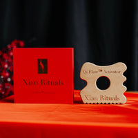 Qi Flow™ Activator next to Red Xian Rituals box on table