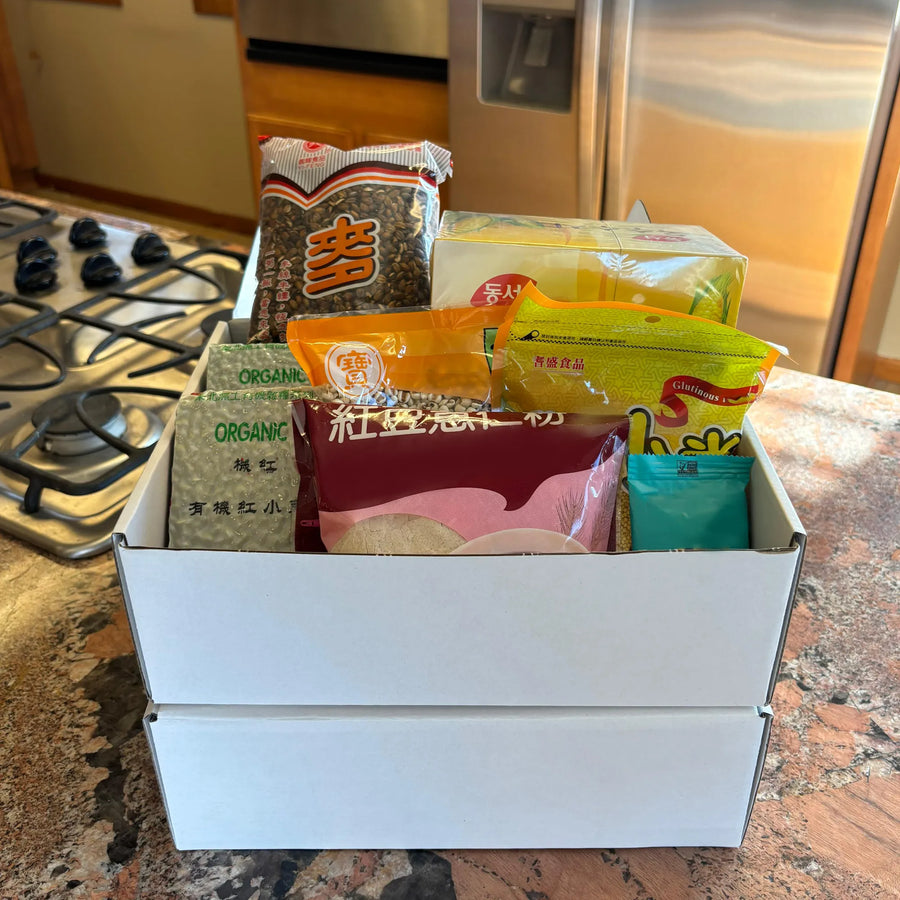 Stacked Qi Reset™ Ritual Kits on a kitchen counter, showcasing seasonal TCM meals for dampness reduction