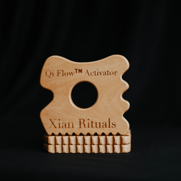 Qi Flow™ Activator stacked on top of two additional Qi Flow™ wooden tools against a dark background—showcasing form, depth, and craftsmanship rooted in Traditional Chinese Medicine