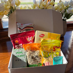 Qi Reset™ Ritual Kit beside flowers on a counter—seasonal Chinese medicine–inspired meal box for internal balance